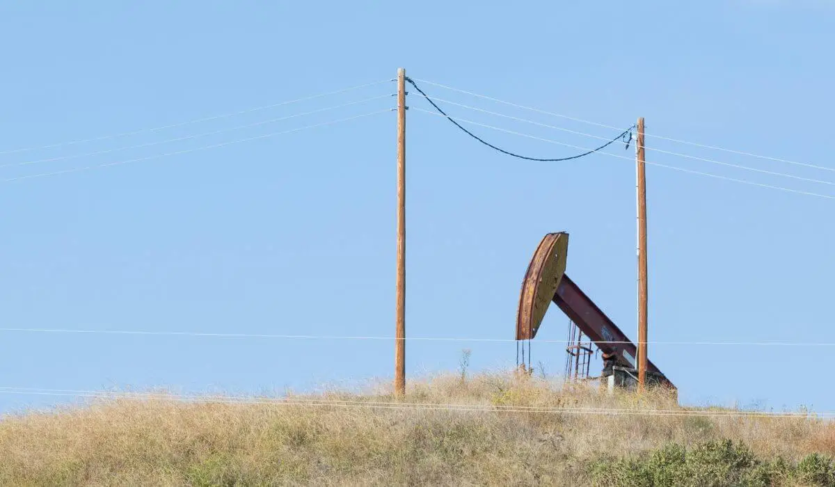 Oil pump jack operating on dry land, representing declining production and its impact on mineral rights value.