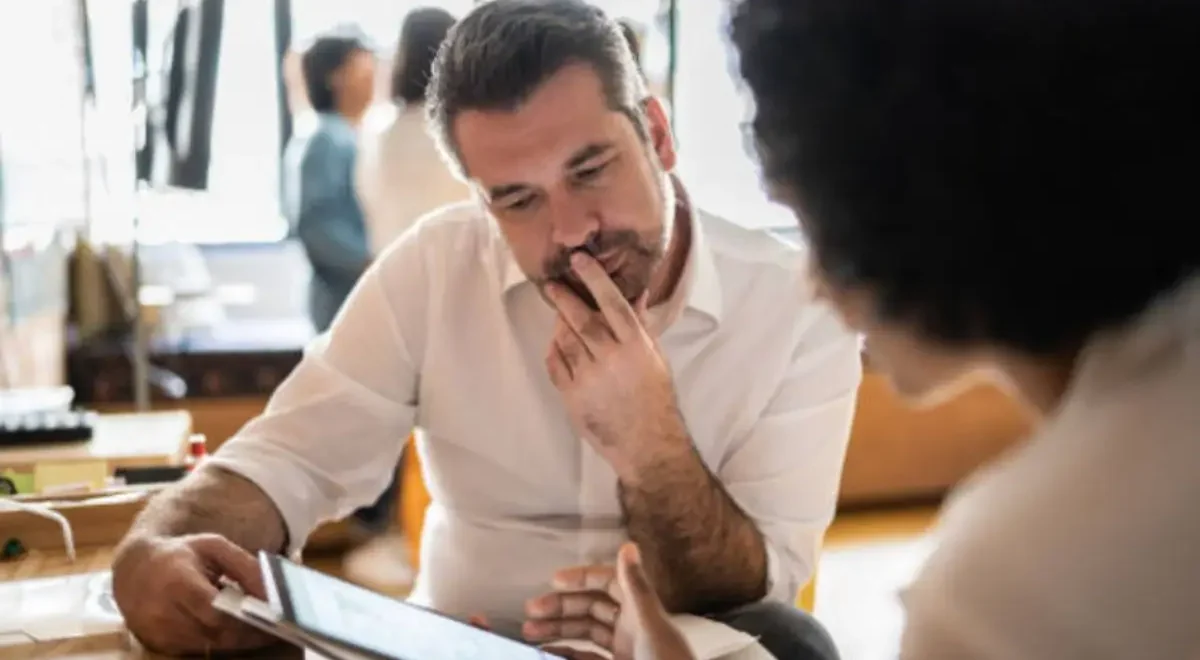 A potential mineral rights seller reviews offer terms with a consultant, illustrating the importance of understanding buyer constraints.