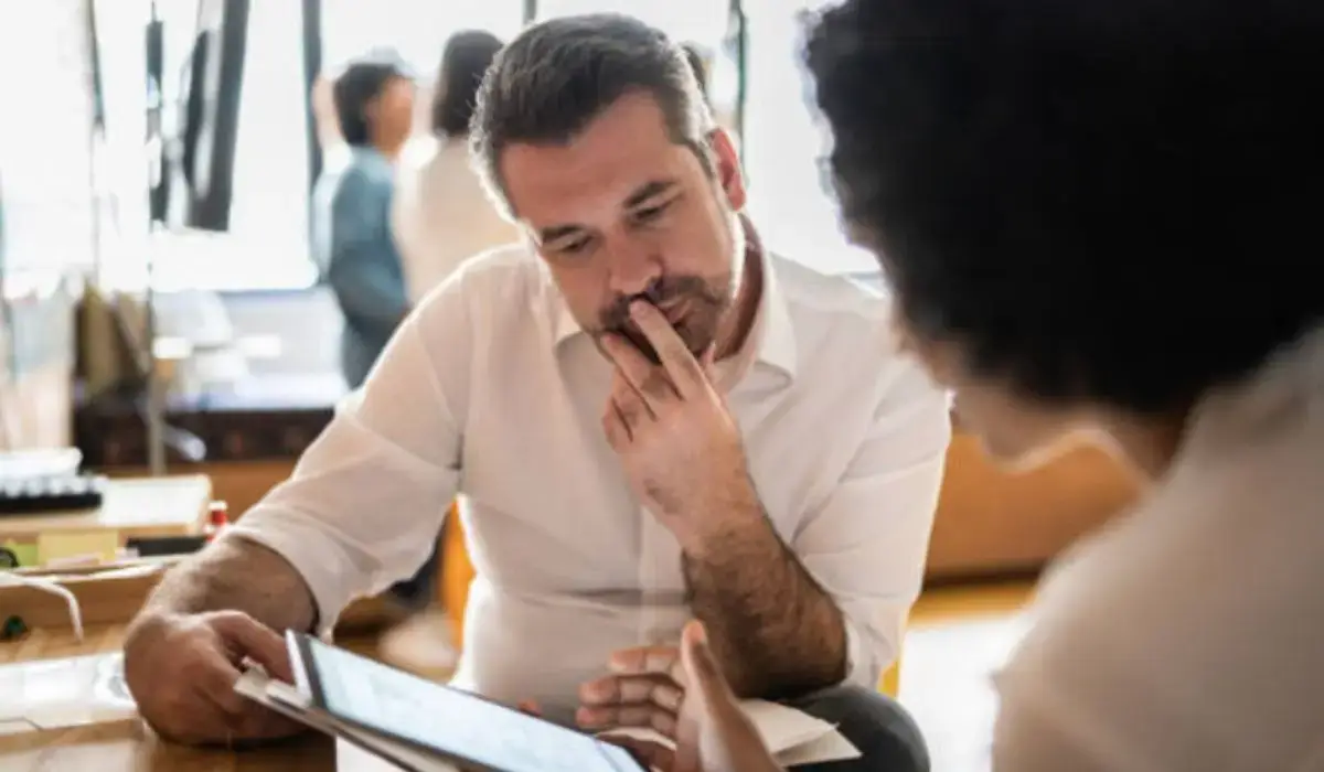A potential mineral rights seller reviews offer terms with a consultant, illustrating the importance of understanding buyer constraints.
